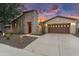 Inviting home featuring a stone tower entry, desert landscaping, and a spacious driveway, creating a striking facade at 28516 N 128Th Dr, Peoria, AZ 85383