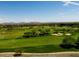 Expansive golf course view featuring lush green fairways, mature trees, sand bunkers, and distant mountain views at 28516 N 128Th Dr, Peoria, AZ 85383