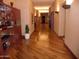 Long hallway featuring hardwood floors, warm lighting, and decorative shelving at 28516 N 128Th Dr, Peoria, AZ 85383