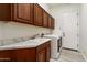 Functional laundry room includes overhead cabinets, sink with ample counter space, and modern washer and dryer at 28516 N 128Th Dr, Peoria, AZ 85383