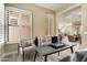 Inviting home office with a sleek desk, cozy armchairs, and natural light from shuttered windows creating an airy workspace at 28516 N 128Th Dr, Peoria, AZ 85383