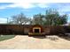 Backyard with stone patio, outdoor fireplace, and beautiful blue skies at 3223 W Rapalo Rd, Phoenix, AZ 85086