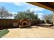 Backyard with stone patio, outdoor fireplace, and manicured landscaping at 3223 W Rapalo Rd, Phoenix, AZ 85086