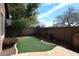 Backyard with synthetic grass, stone patio, and block wall at 3223 W Rapalo Rd, Phoenix, AZ 85086