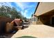 Backyard with stone patio, outdoor fireplace, and lush landscaping at 3223 W Rapalo Rd, Phoenix, AZ 85086