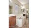 Bright bathroom featuring a soaking tub with a privacy window, double vanities and tile flooring at 3223 W Rapalo Rd, Phoenix, AZ 85086