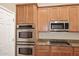 Modern kitchen featuring stainless steel appliances and granite countertops, paired with wooden cabinetry at 3223 W Rapalo Rd, Phoenix, AZ 85086