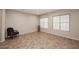 Minimalist living room with tile flooring, two large windows, and a comfortable armchair at 3223 W Rapalo Rd, Phoenix, AZ 85086