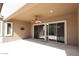 Covered patio featuring stone flooring, a ceiling fan and sliding glass doors to the interior at 3223 W Rapalo Rd, Phoenix, AZ 85086