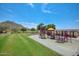 Spacious playground with various structures set against a backdrop of green grass and mountain views at 3223 W Rapalo Rd, Phoenix, AZ 85086