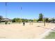 Residents enjoying a game on the sand volleyball court in a community park with blue skies overhead at 3223 W Rapalo Rd, Phoenix, AZ 85086