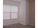 An interior bedroom view with light-colored walls, neutral carpet, and a window with bright natural light at 330 S Farmer Ave # 121, Tempe, AZ 85281