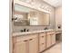 Bathroom boasting dual sinks with granite counters, a vanity, and a framed mirror with lighting at 4061 N Point Ridge Rd, Buckeye, AZ 85396