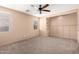 Spacious carpeted bedroom featuring neutral walls, a ceiling fan, and ample natural light at 4061 N Point Ridge Rd, Buckeye, AZ 85396