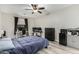 Bedroom showcasing a ceiling fan, wood flooring, a comfortable bed with a blue comforter, and a home office setup at 4170 N 154Th Dr, Goodyear, AZ 85395