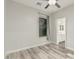 A bright bedroom featuring wood-look flooring, modern ceiling fan, and an ensuite bathroom at 4170 N 154Th Dr, Goodyear, AZ 85395