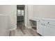 Hallway with a built in desk, cabinets, and wood-look flooring leading to another room with a large window at 4170 N 154Th Dr, Goodyear, AZ 85395