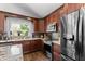 Modern kitchen featuring stainless steel appliances, granite counters, and dark wood cabinets at 4440 W Fallen Leaf Ln, Glendale, AZ 85310