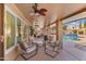 Inviting covered patio featuring comfortable seating, ceiling fans, and views of the sparkling pool at 4440 W Fallen Leaf Ln, Glendale, AZ 85310