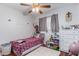 A charming bedroom featuring a cozy single bed with a ceiling fan and storage shelves at 4512 E Turney Ave, Phoenix, AZ 85018