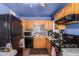 Functional kitchen with wood cabinetry, essential appliances, and a mosaic tile backsplash at 4512 E Turney Ave, Phoenix, AZ 85018