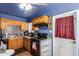 Well-lit kitchen features honey oak cabinets, essential appliances, and access to the home's exterior at 4512 E Turney Ave, Phoenix, AZ 85018