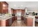 Spacious kitchen with dark wood cabinets, stainless steel appliances, and tiled backsplash, perfect for cooking and entertaining at 4705 W Annette Cir, Glendale, AZ 85308