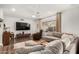 Cozy living room with neutral sectional sofa, a TV, wood floors, and a view of the backyard at 4705 W Annette Cir, Glendale, AZ 85308