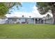 Expansive backyard with lush green grass, covered patio, and block wall at 5307 E Cambridge Ave, Phoenix, AZ 85008