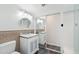 Bathroom featuring vanity, tile accents, round mirror, and sliding shower door at 5307 E Cambridge Ave, Phoenix, AZ 85008