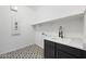 Well-lit laundry room with black cabinets, patterned tile floor, sink, and extra shelving space at 5340 S Sabrina --, Mesa, AZ 85212