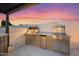 Well-equipped outdoor kitchen with a built-in grill, sink, and tiled backsplash perfect for entertaining at 5340 S Sabrina --, Mesa, AZ 85212