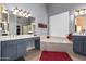 Elegant bathroom with a large window over the tub, dual sinks, and updated fixtures at 6531 E Star Valley St, Mesa, AZ 85215