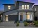 Charming two-story home featuring a gray garage door, modern design, and manicured landscaping at 6735 N 9Th Dr, Phoenix, AZ 85013