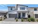 Stunning two-story home featuring a gray garage door, modern design, and desert landscaping at 6735 N 9Th Dr, Phoenix, AZ 85013