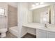 Well-lit bathroom with a shower, tiled floors, and a vanity with a large mirror at 7413 N 67Th Dr, Glendale, AZ 85303