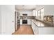 Bright kitchen featuring stainless steel appliances, white cabinets, and tiled backsplash at 7413 N 67Th Dr, Glendale, AZ 85303