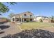 Spacious backyard with lush green grass, a covered patio, and mature palm trees at 7421 S 25Th Ln, Phoenix, AZ 85041