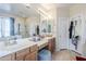 Bathroom with dual vanity sinks, a walk-in shower, and a large mirror at 7421 S 25Th Ln, Phoenix, AZ 85041