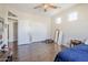 Bedroom featuring a ceiling fan, hardwood floors, and three windows at 7421 S 25Th Ln, Phoenix, AZ 85041