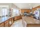 Bright, open kitchen with light wood cabinets, granite counters, and a view to the backyard at 7421 S 25Th Ln, Phoenix, AZ 85041