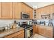 Cozy kitchen view featuring granite countertops, wooden cabinets, and stainless steel appliances at 7421 S 25Th Ln, Phoenix, AZ 85041