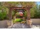 Serene backyard with a shaded pergola and lush landscaping at 7693 E Via Del Sol Dr, Scottsdale, AZ 85255