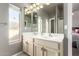 Bright bathroom with double sinks, natural light, and light colored cabinets next to another ' bedroom at 7693 E Via Del Sol Dr, Scottsdale, AZ 85255