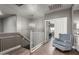 A bright hallway with wood floors, a staircase, and a cozy blue chair near an open doorway at 7693 E Via Del Sol Dr, Scottsdale, AZ 85255