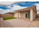 This covered back patio features a brick floor, artificial turf, and access to the home at 8957 W Palo Verde Dr, Glendale, AZ 85305