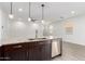 Kitchen island featuring granite countertops, pendant lighting, stainless steel dishwasher, and tile flooring at 8957 W Palo Verde Dr, Glendale, AZ 85305