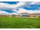 Community playground featuring a covered play structure, picnic tables, and a sprawling grassy area for recreational activities at 8957 W Palo Verde Dr, Glendale, AZ 85305