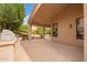 Covered backyard patio featuring an outdoor kitchen and a stone tile floor at 9104 E Hillery Dr, Scottsdale, AZ 85260