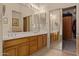 Spacious bathroom featuring double sinks, a mirrored closet, and natural-colored walls at 9104 E Hillery Dr, Scottsdale, AZ 85260